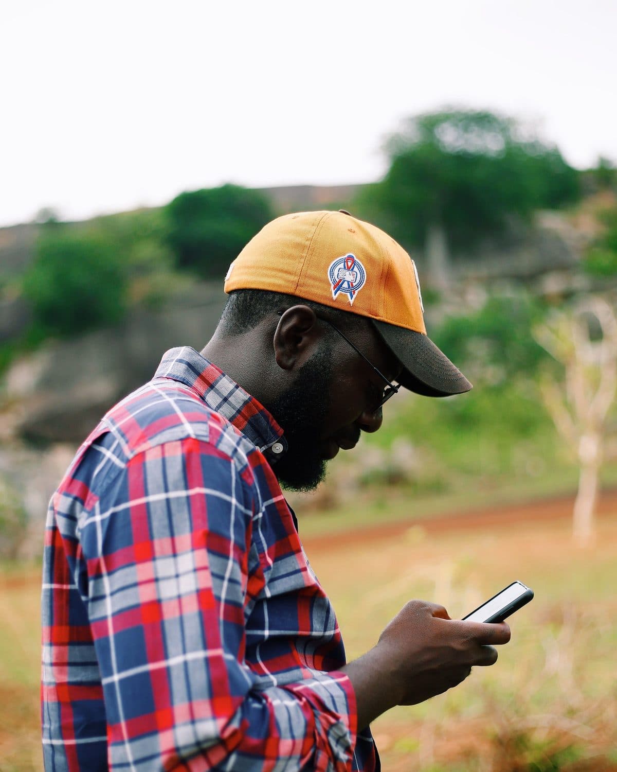 En pleine campagne, un homme consulte son téléphone.